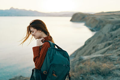 Young woman standing in sea against sky