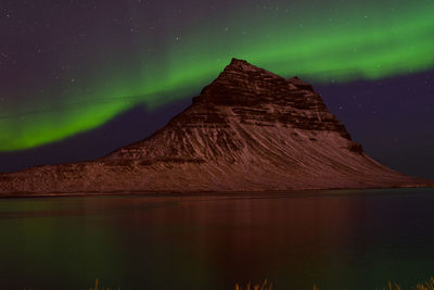 Scenic view of lake and rock formation against sky at night