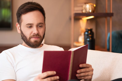 Portrait of young man reading book