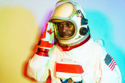 Close-up portrait of young man against colored background