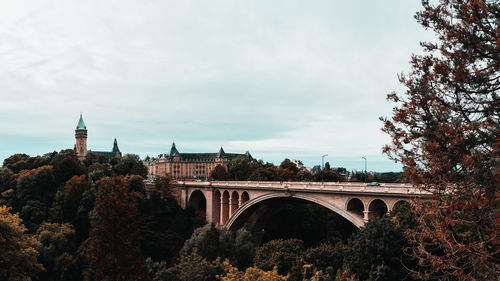 Arch bridge over building against sky