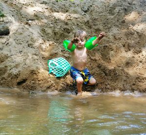 Full length of happy boy swimming in river