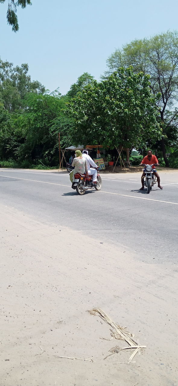 PEOPLE RIDING MOTORCYCLE ON STREET