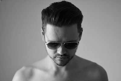 Close-up portrait of shirtless man against white background