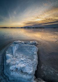 Scenic view of frozen sea against sky during sunset