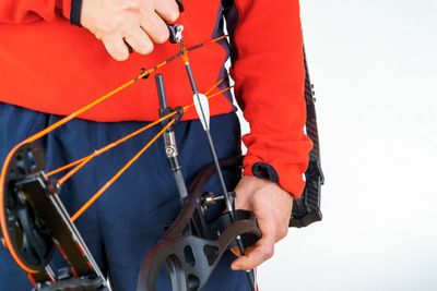 Midsection of archer holding cross bow against white background