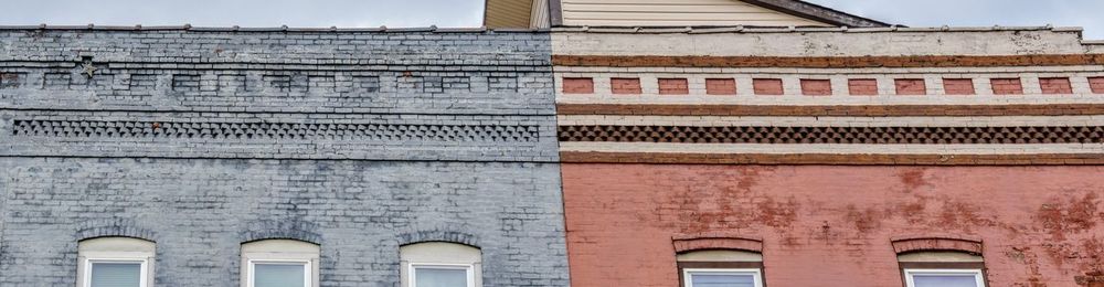 Close-up of commercial old brick building, roofs brick design in grey shifting to red.
