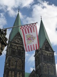 Low angle view of flag against sky in city