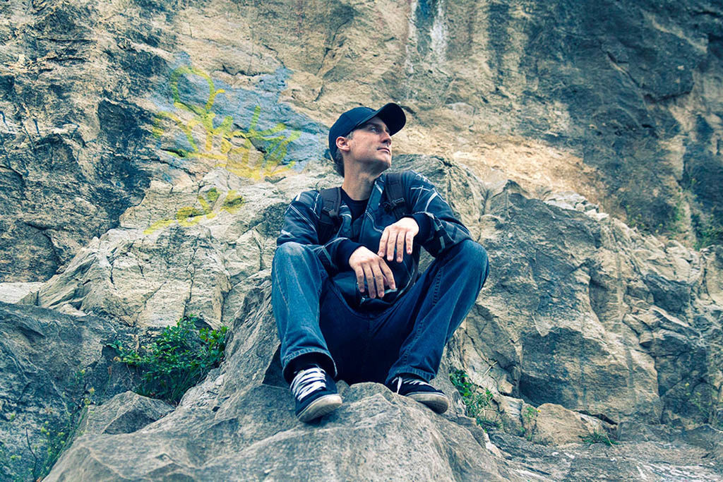 FULL LENGTH OF MAN SITTING ON ROCK