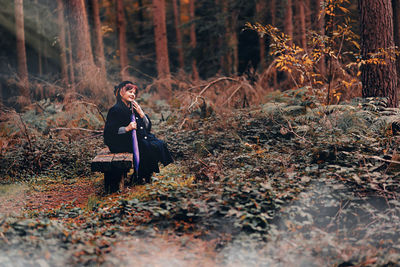 Rear view of woman standing in forest