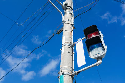 Low angle view of street light against blue sky