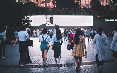 Group of people walking on zebra crossing in city