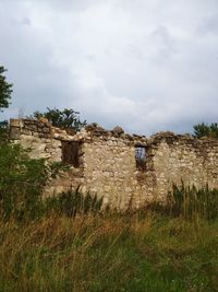 Old ruin on field against sky