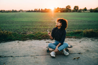 Full length of man sitting on field