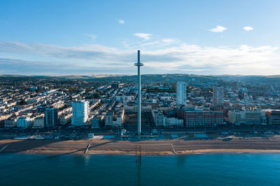 Aerial shot of brighton with the i360 and beach in the morning light with wispy cloud and blue sky