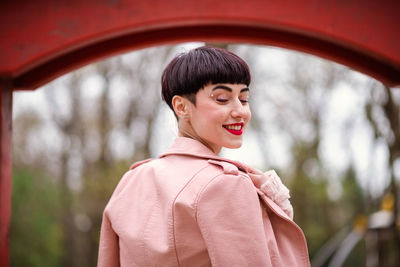 Smiling fashion model standing at park