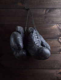 Close-up of boxing gloves hanging on wooden wall