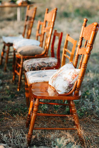 Empty chairs and table on field