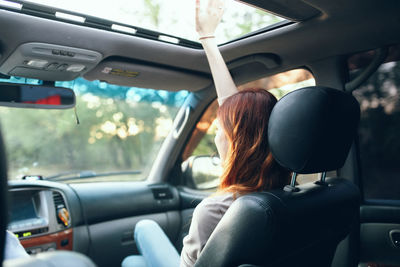 Rear view of woman sitting in car