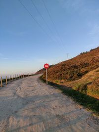 Road leading towards bridge against sky