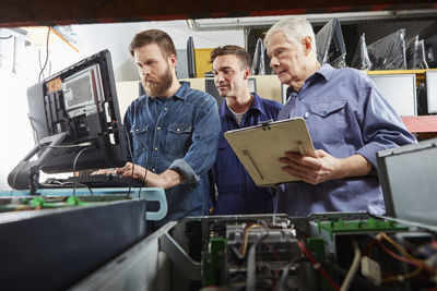 People in computer recycling plant checking desktop pc