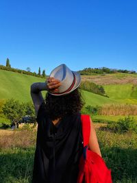 Girl admires green wheat countryside