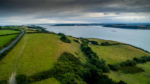 High angle view of landscape by sea against cloudy sky