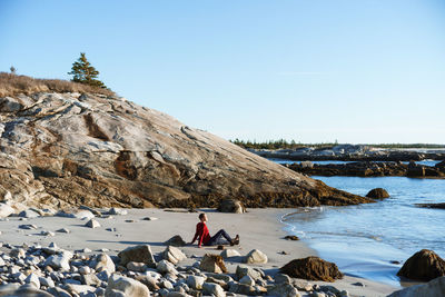 Man at sea shore against clear sky