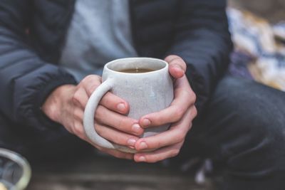 Midsection of man holding coffee