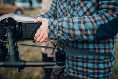 Midsection of man photographing with mobile phone