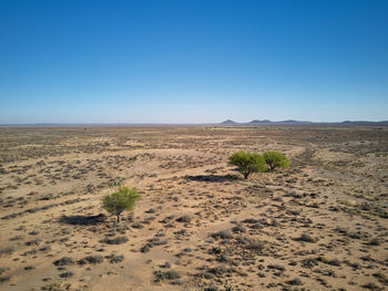 Scenic view of desert against clear blue sky