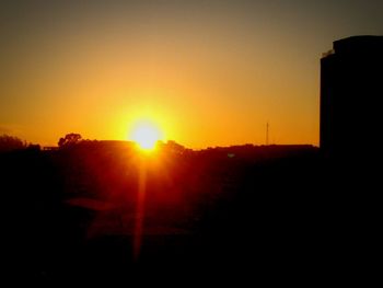 Silhouette landscape against clear sky during sunset