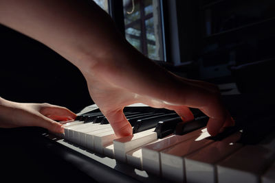 Cropped hands playing piano