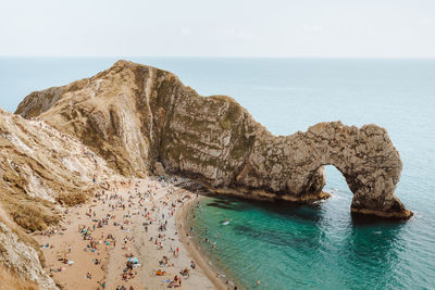 Rock formations on sea shore against sky