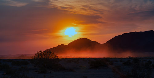 Scenic view of silhouette mountains against sky during sunset