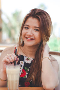 Portrait of smiling woman drinking glass