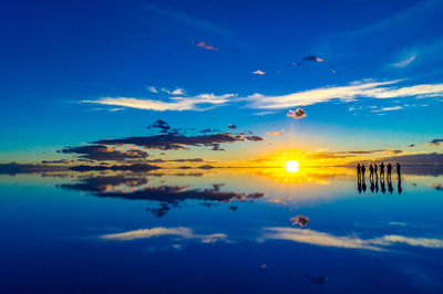 Scenic view of salt flat against sky at sunset