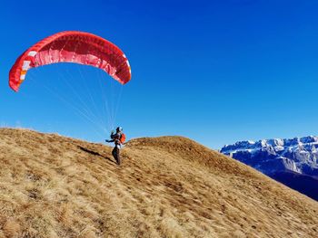 Person paragliding against blue sky