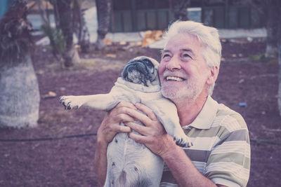 Senior man holding pug