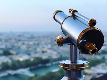 Close-up of coin-operated binoculars against cityscape