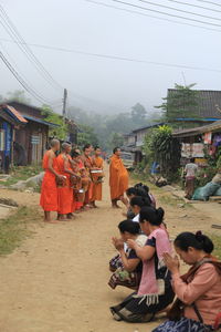 Rear view of people on beach against sky