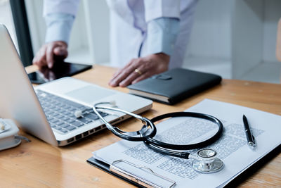 Midsection of man using laptop on table