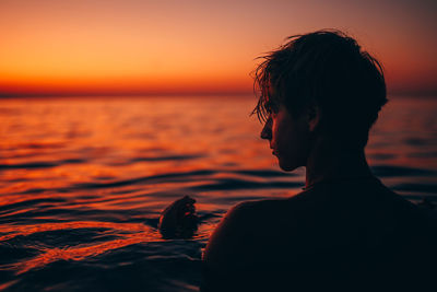 Silhouette person on beach against sky during sunset