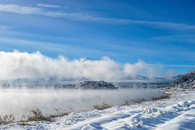 Scenic view of snow covered landscape against blue sky