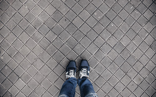 Low section of person standing on tiled floor