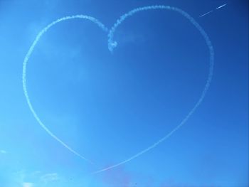 Low angle view of vapor trail against clear blue sky