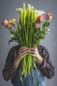 Unrecognizable female professional florist making bouquets of various types. roses. yellow flowers. coves