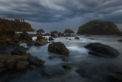 Rocks on sea shore against sky