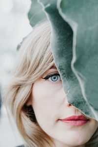 Close-up portrait of woman by leaf