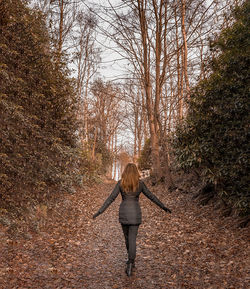 Rear view of woman walking in forest